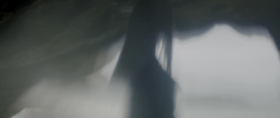 A woman is walking in a cave by the water
