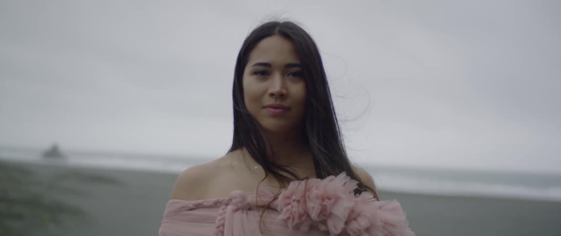 A woman smiles near the beach