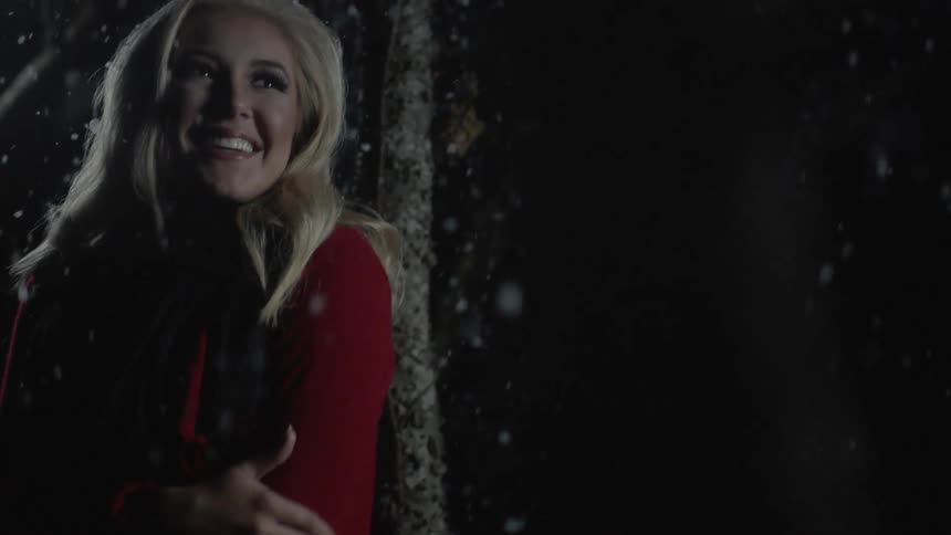 Woman smiling and shivering outside on a snowy night
