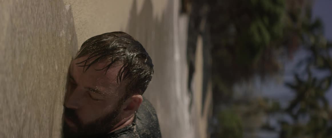 A man is lying face down in the beach water