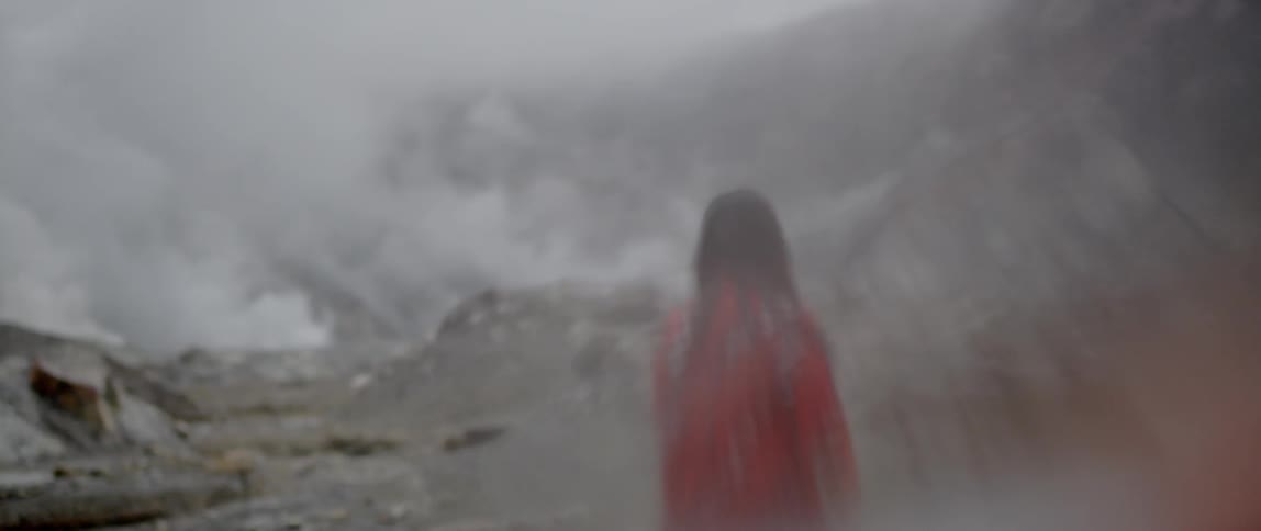 A woman walks in the fog on the mountain