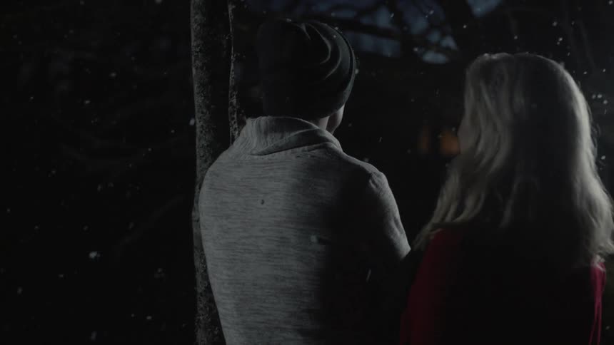 Man and woman standing outside on a snowy night
