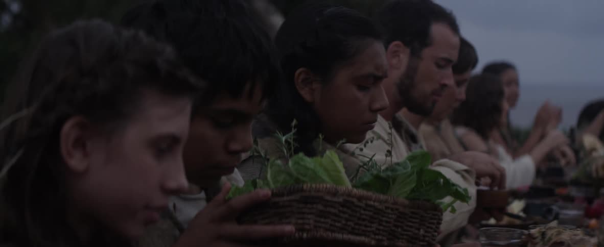 A boy grabs a basket of food at an outdoor feast