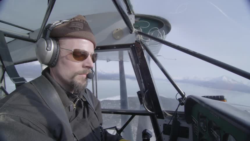 Man driving an airplane on a cloudy day