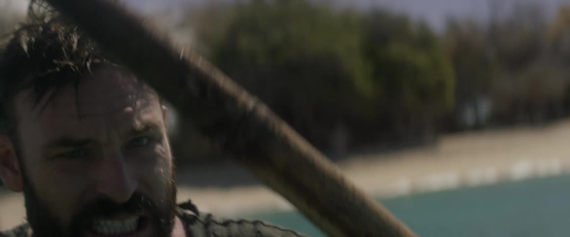 Angry looking man paddles a boat in a body of water