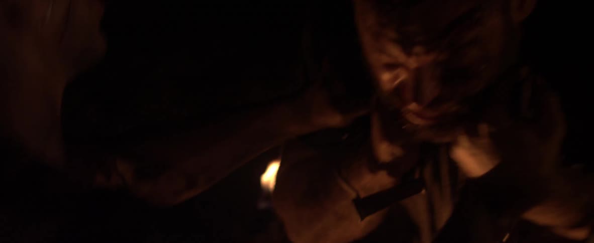 Two people fight in dim light