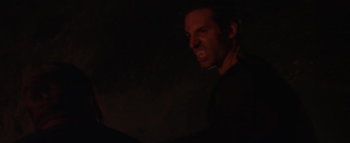 A caveman punches a man in the face knocking him down