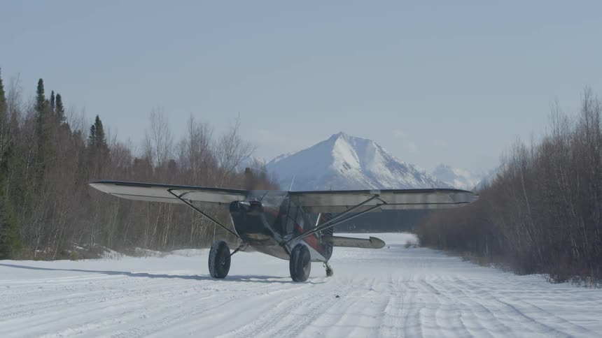 A plane slowly moves on a snow covered area