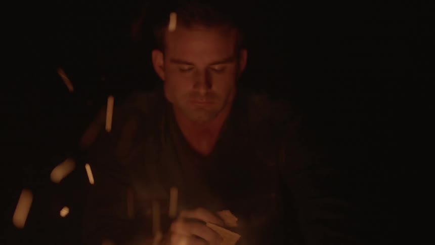 Man eating graham crackers in front of a campfire