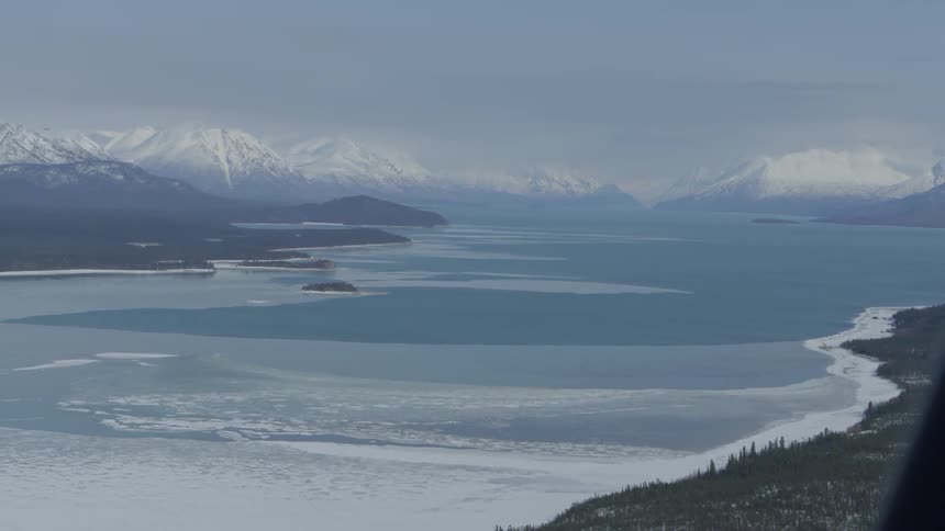 Aerial view of a frozen lake and mountain range