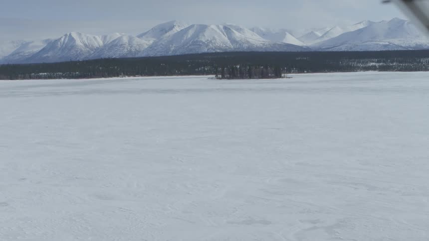 Large icy field with mountains in the background