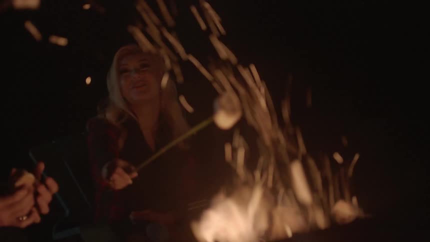 A woman is making food on a campfire