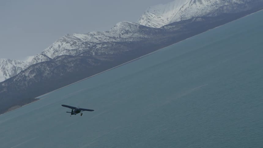Small airplane flying sideways over a body of water
