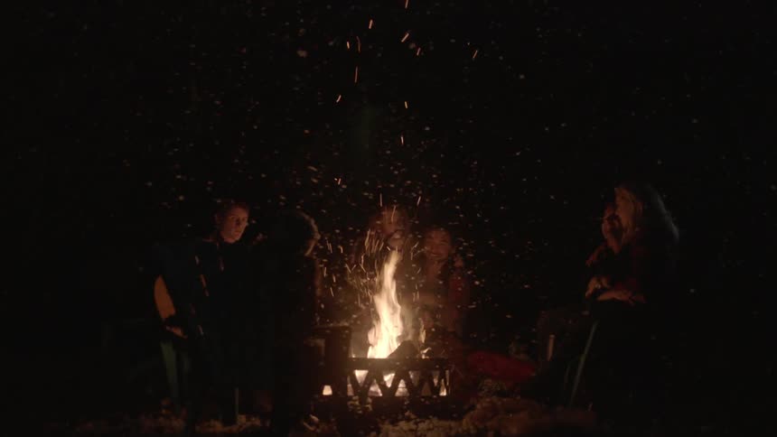 People sitting around a campfire at night
