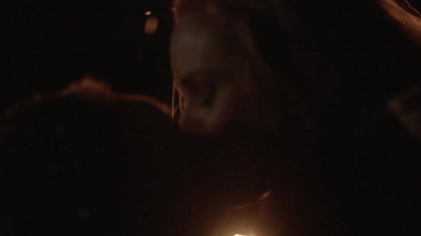 A couple kissing by a fire