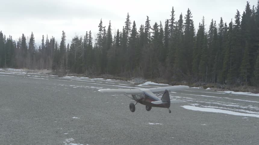 A small airplane taking off from a forest field
