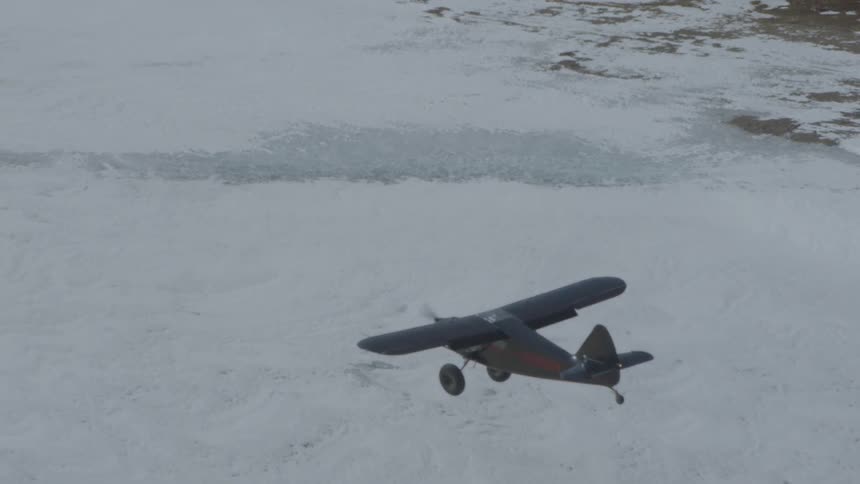 A plane flying over frozen tundra