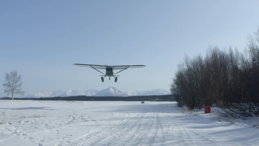 A plane landing in the snow