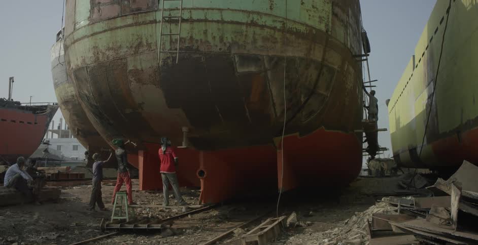 Construction workers work on a barge outdoors