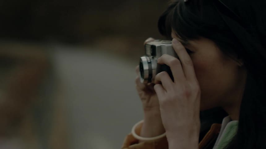 A woman takes a photograph of the water