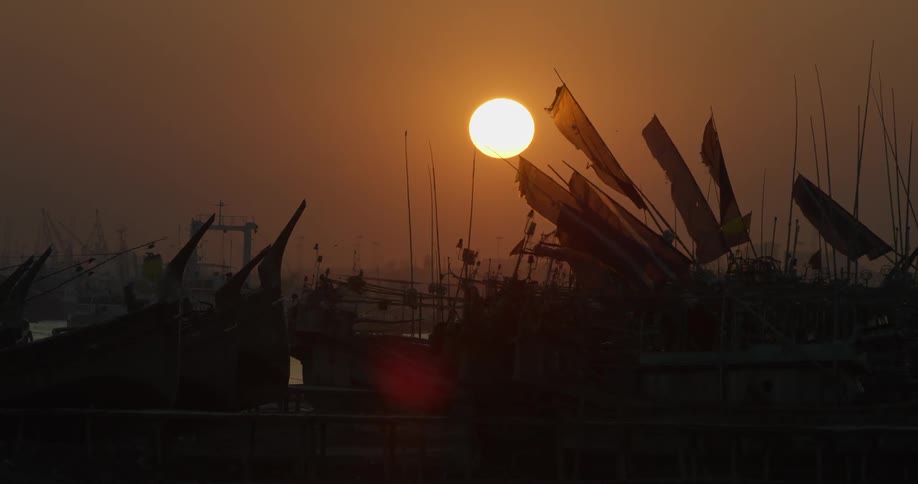 Sun shining over many boats in a harbor