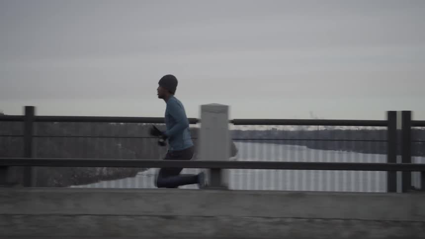A man is running across the bridge