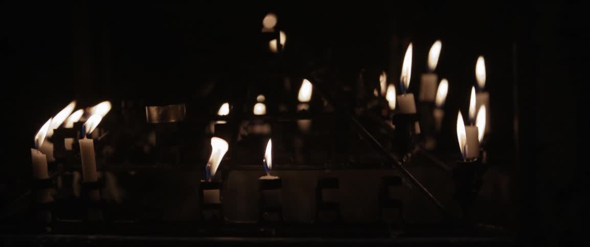 A bunch of candles are lit and burning