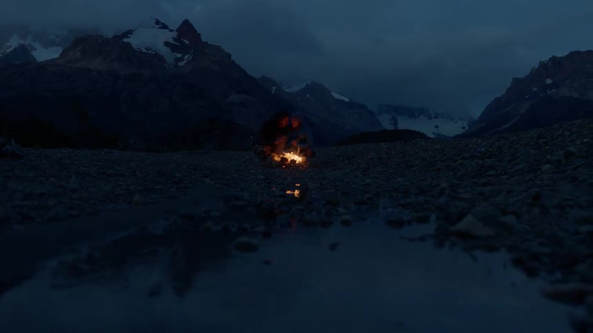 Two people sitting by a fire at night