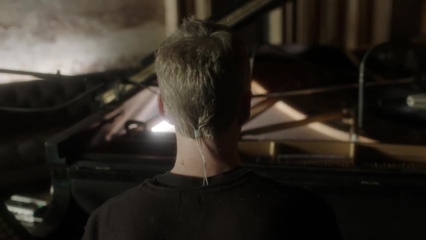 A man plays piano in a music studio