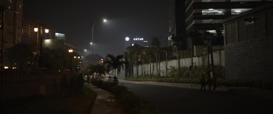 Pedestrians walk on a city street at night