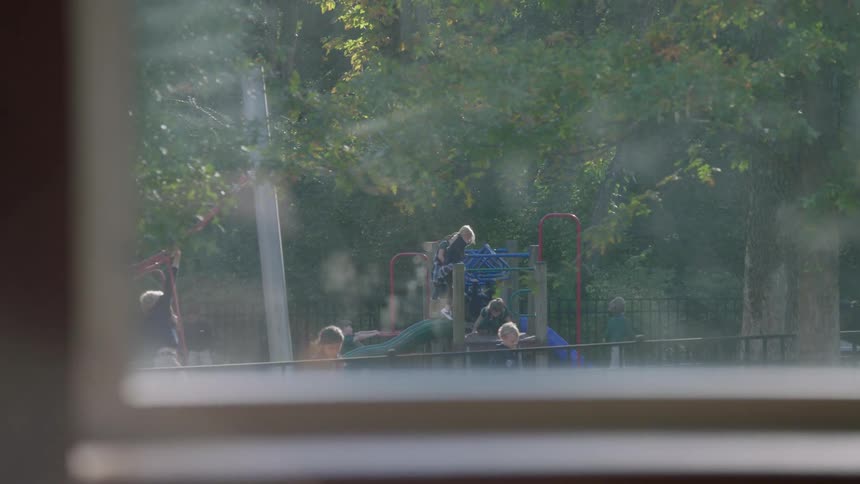 View looking out a window at children playing on a playground