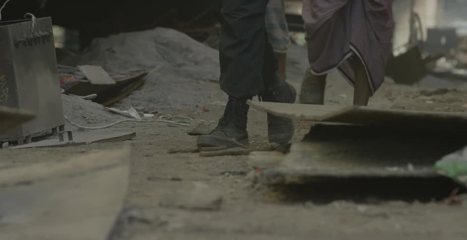 People walk down the alley covered with debris