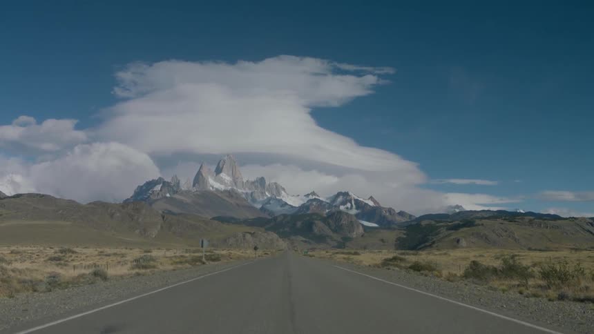 The road is empty and a mountain is at the end