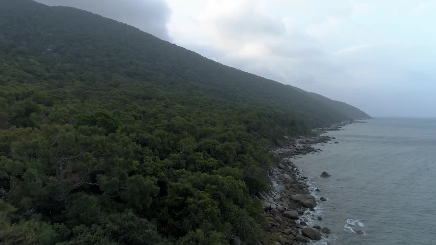 The green mountain is lined by water