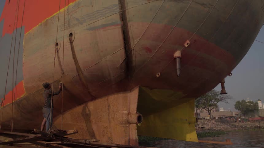A person is working on a large boat