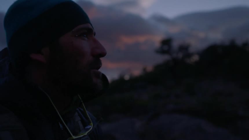 Wind blows around a man at sunset