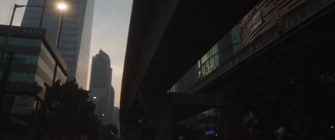 A concrete structure appears to wrap around a building at sunset