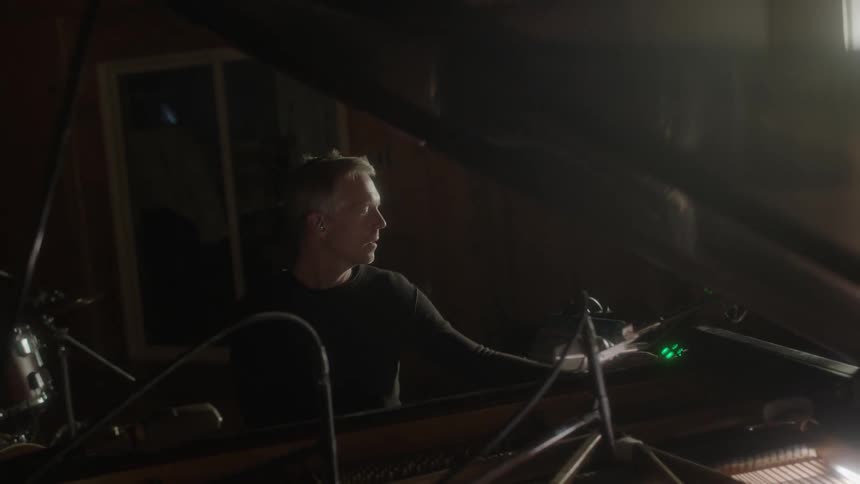 A man is playing musical instruments in a studio