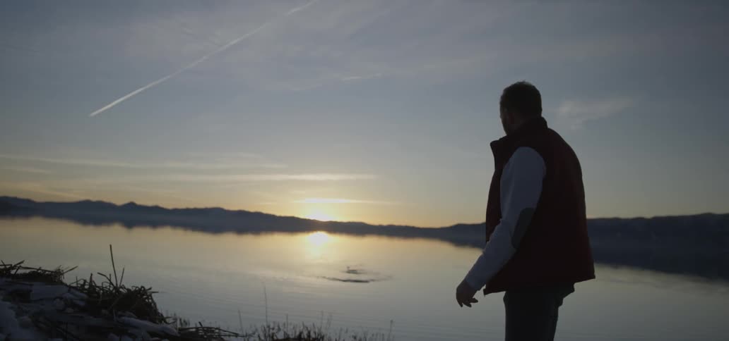 A man is skipping a stone across a lake
