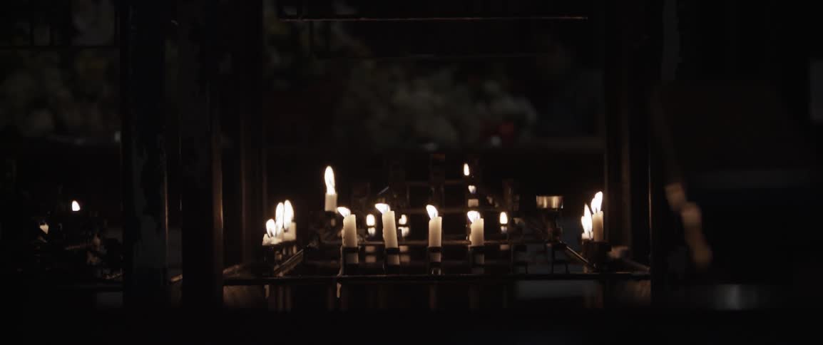 The candles line the table in the dark