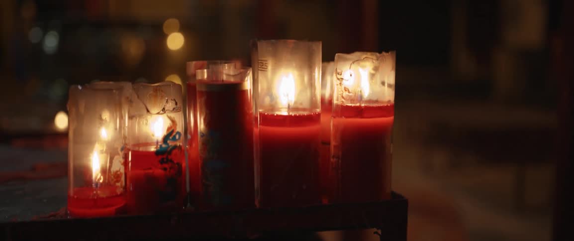 Many burning candles inside dim room