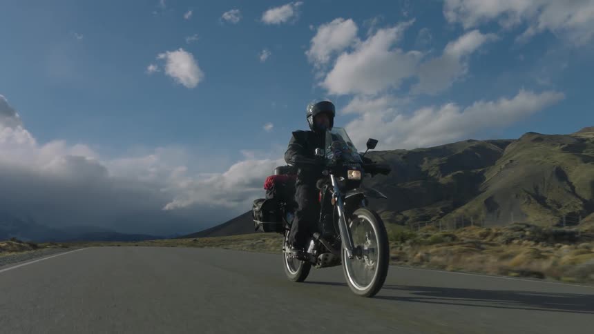 A person rides their motorcycle down the road