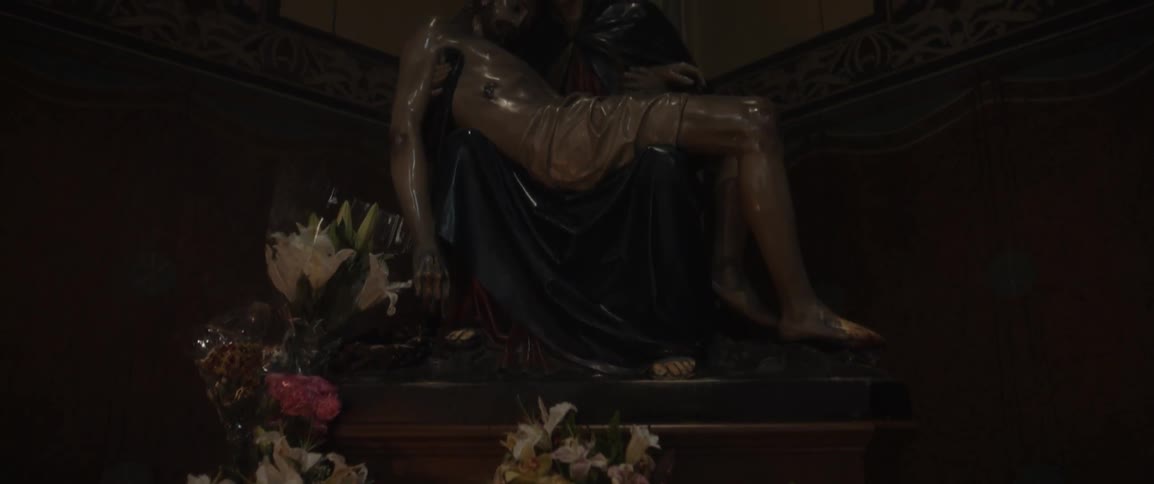 Bouquets of flowers below a statue of two people