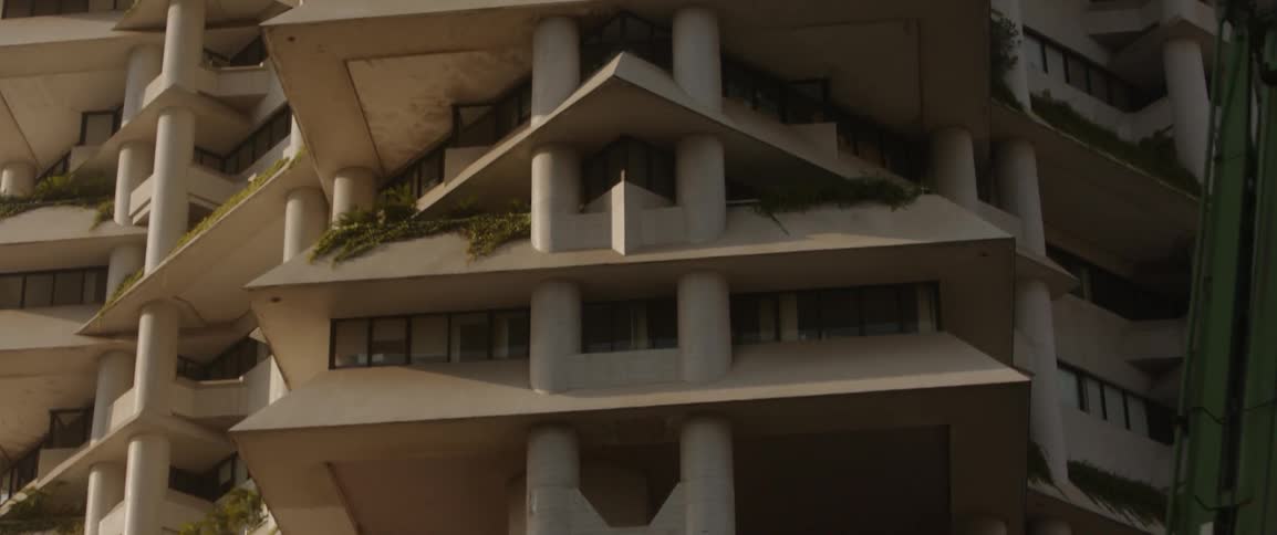 A vehicle drives by a tall city building