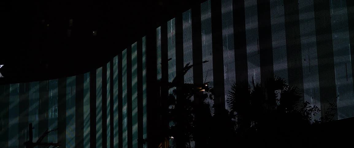 A projection is cast on a building at night