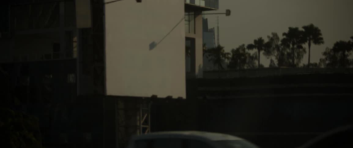 Vehicles drive in the city with tall buildings