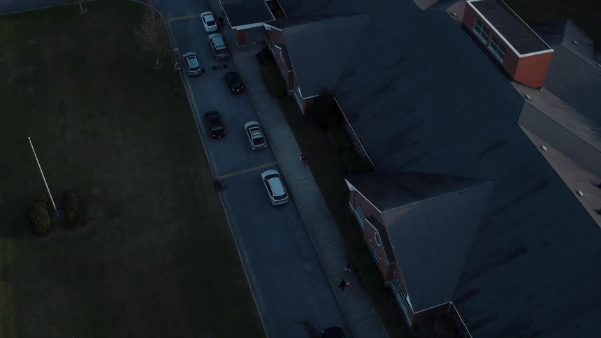 Cars drive down the road past the large house