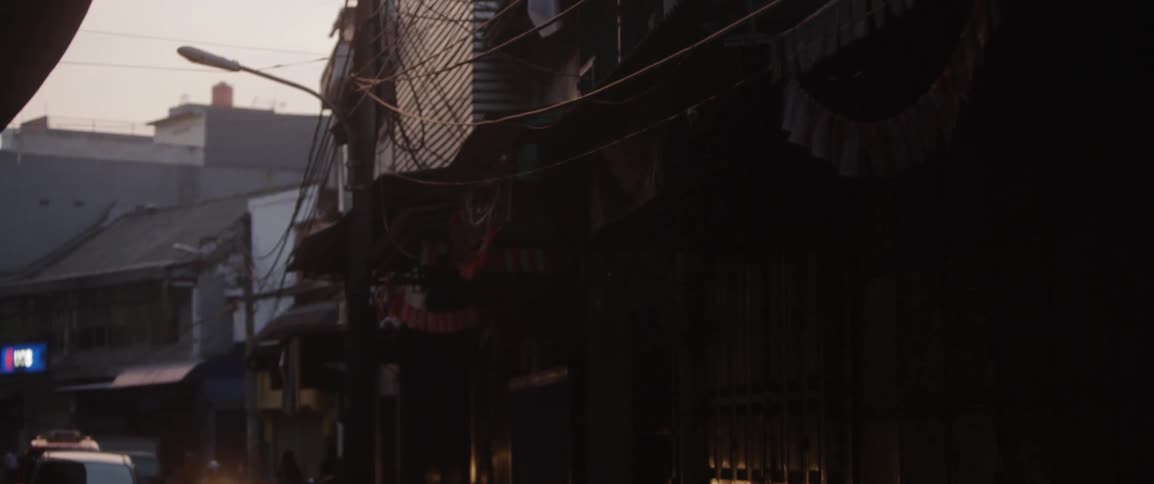 Power lines run along these buildings in the alley