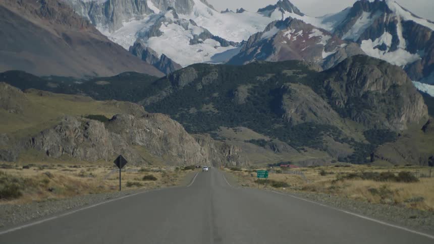 A vehicle drives on a mountain road