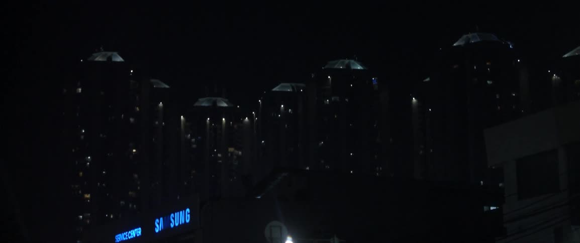 Passing by lit up signs and buildings in city at night